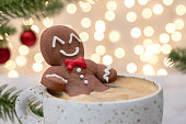 Gingerbread cookie man in a hot cup of cappuccino