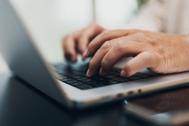 istock closeup of hands typing on a notebook, keyboard 1443496768