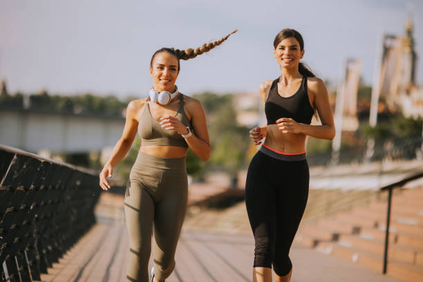 istock Young woman taking running exercise by the river promenade 1443497603