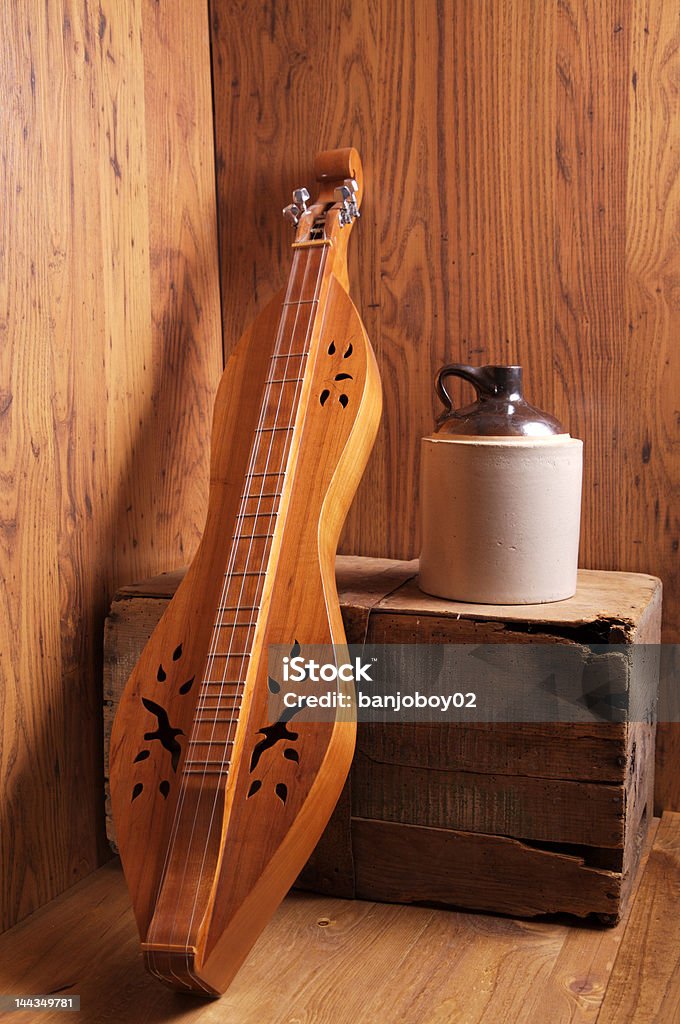 Mountain Music A mountain dulcimer leaning against an old wooden box with a ceramic jug Box - Container Stock Photo