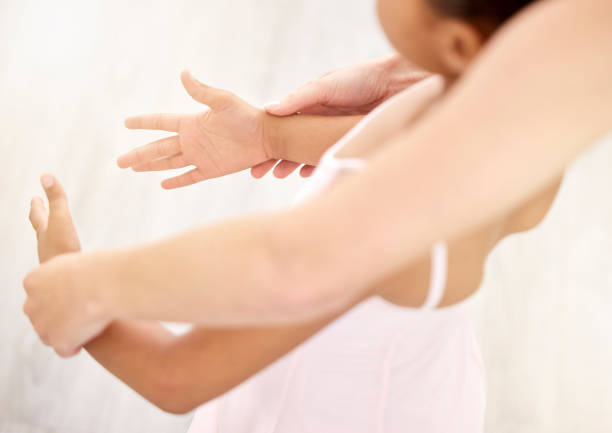 istock Hands, ballet and dance with a teacher and student in a class for dancing or performance arts. Artistic, dancer and learning with a girl ballerina in a classroom with an instructor from above 1443498066