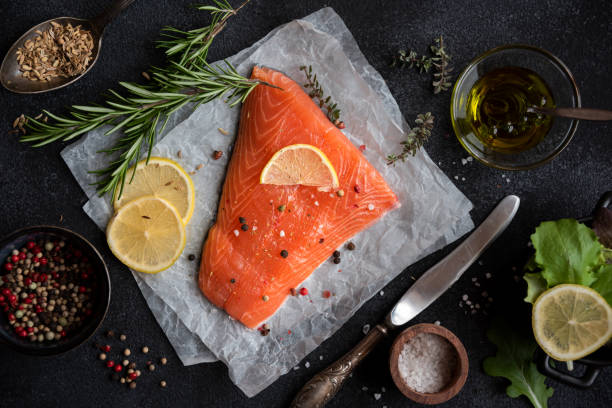 istock Uncooked raw salmon fish with herbs on dark background 1443499642
