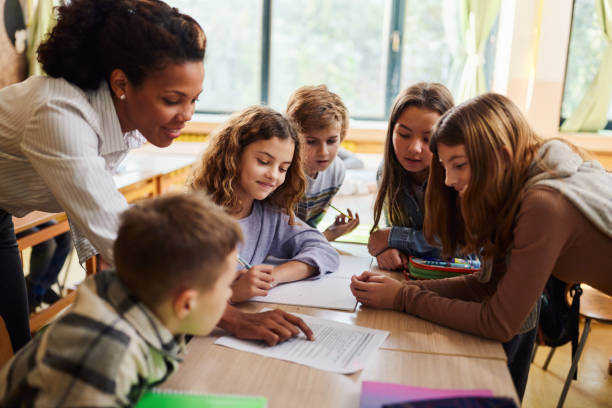 istock Happy black teacher and school kids learning at elementary school. 1443499818