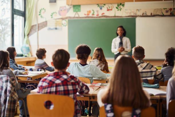 widok z tyłu uczniów szkół podstawowych uczęszczających na zajęcia w klasie. - school classroom child back to school zdjęcia i obrazy z banku zdjęć