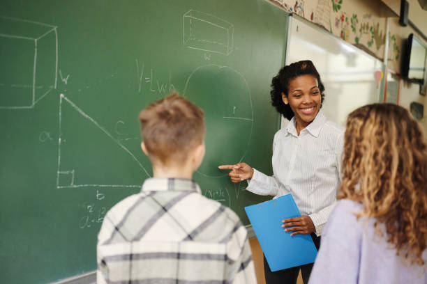 istock African American teacher explaining geometry to schoolkids during a class at elementary school. 1443500366