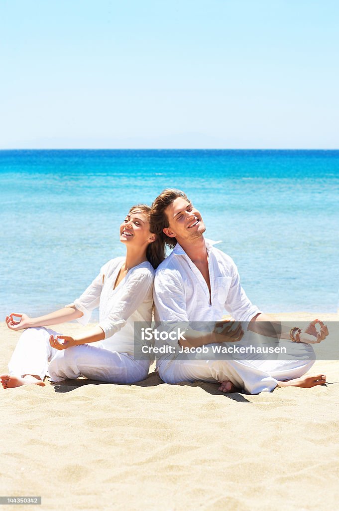 Casal meditating na praia - Foto de stock de Adulto royalty-free