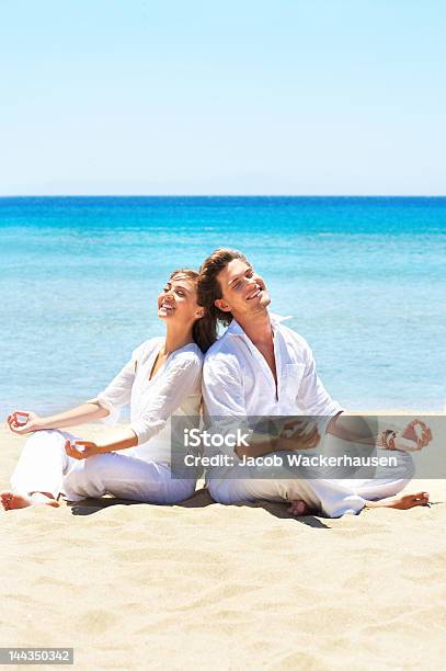 Foto de Casal Meditating Na Praia e mais fotos de stock de Adulto - Adulto, Alegria, Amor
