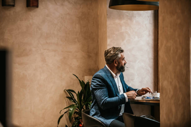 istock Modern senior businessman smokes a cigarette while resting in a cafe after a hard day's work 1443506165