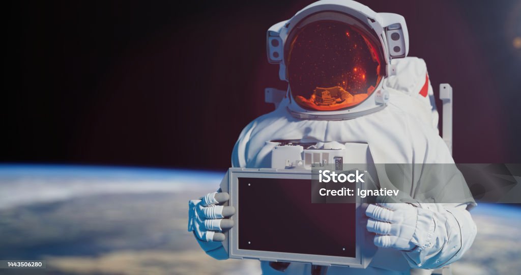 The banner is in the hands of an astronaut. Spaceman holding a chroma key screen, standing against the Earth in an outer space Spaceman holding a chroma key screen, standing against the Earth in an outer space Astronaut Stock Photo
