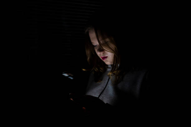 Blackout. Energy crisis. Destruction of infrastructure. Power outage concept. Girl using smartphone in dark room