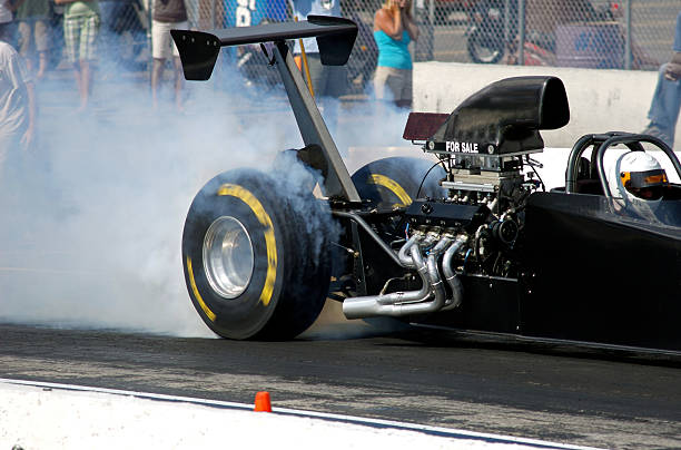 Race Car burning rubber smoking tires Burning rubber at the start of the drag race drag racing stock pictures, royalty-free photos & images