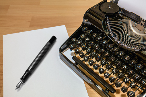 Old antique typewriter with fountain pen and paper