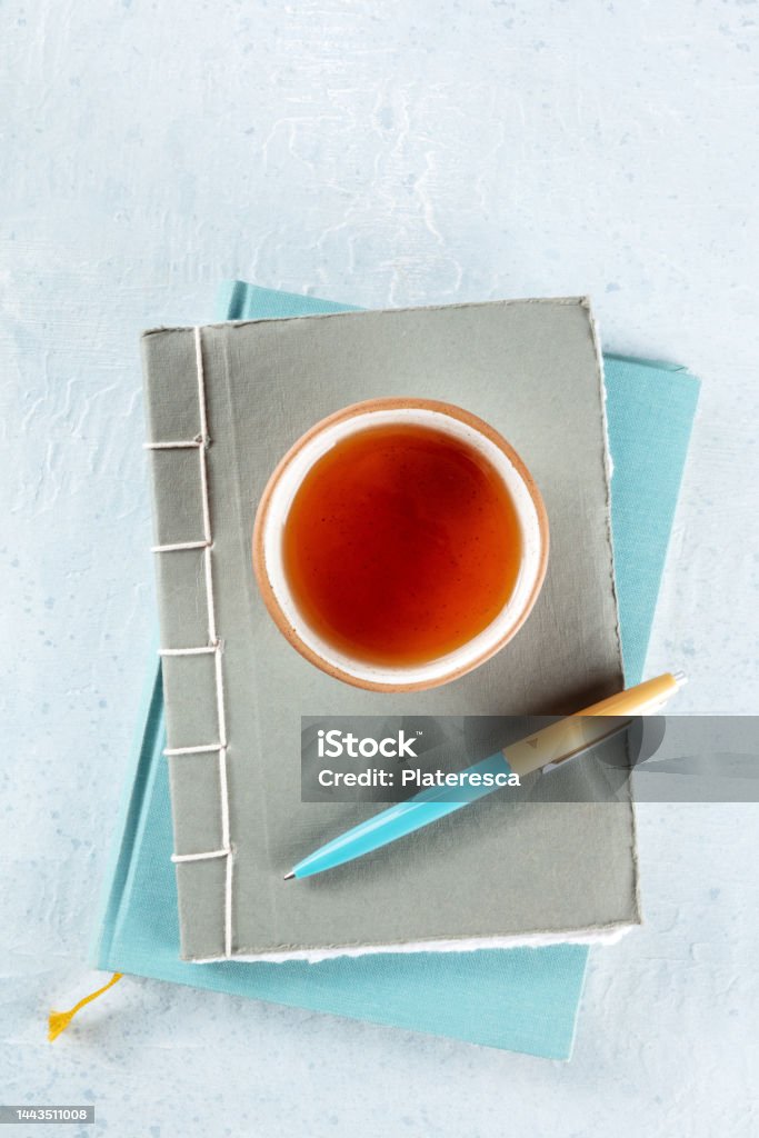 A diary. Journals with a pen and a cup of tea, minimalist style, top shot A diary. Journals with a pen and a cup of tea, minimalist style, shot from the top on a desk Diary Stock Photo