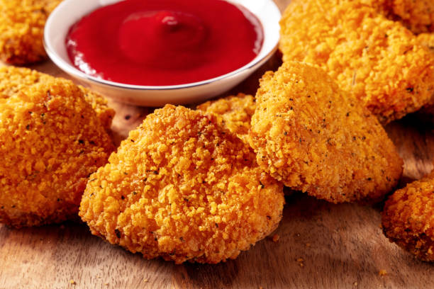 istock Chicken nuggets with ketchup close-up on a rustic wooden board 1443511464