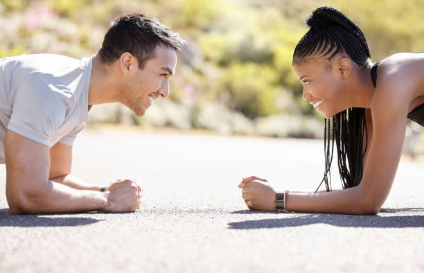 Energy, exercise and couple workout outdoors, bonding while being playful and competitive in nature. Training, motivation and interracial relationship by man and woman enjoy cardio plank challenge energía, ejercicio y entrenamiento de plancha en pareja al aire libre, vinculación, juguetón y competitivo en la naturaleza. el entrenamiento, la motivación y la relación interracial entre hombres y mujeres disfrutan del desafío cardio fitness