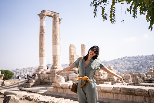 Portrait of a happy tourist in antique columns, Amman city, Jordan