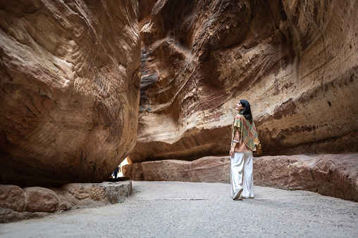 Turista adulta mediana caminando y admirando Petra, Jordania photo