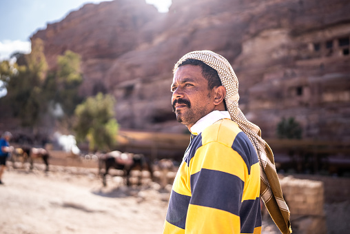 Mid adult middle eastern man looking away contemplating outdoors