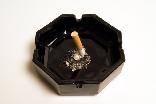 stubbed out cigarette in black ash tray