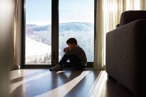 istock Depressed boy sitting in the room 1443517545