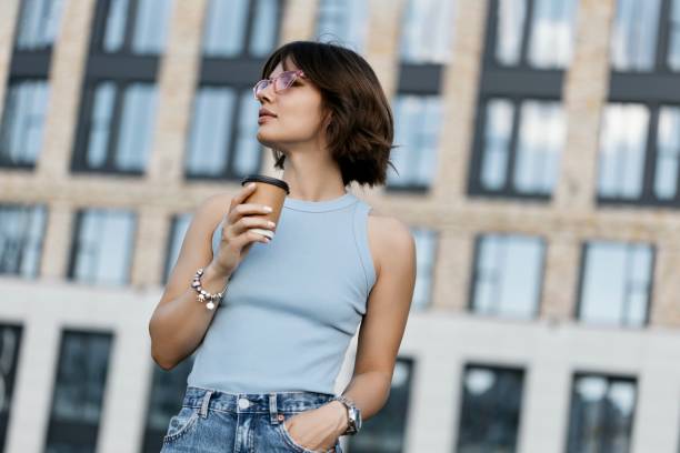 istock Woman holding coffee in paper cup 1443518573