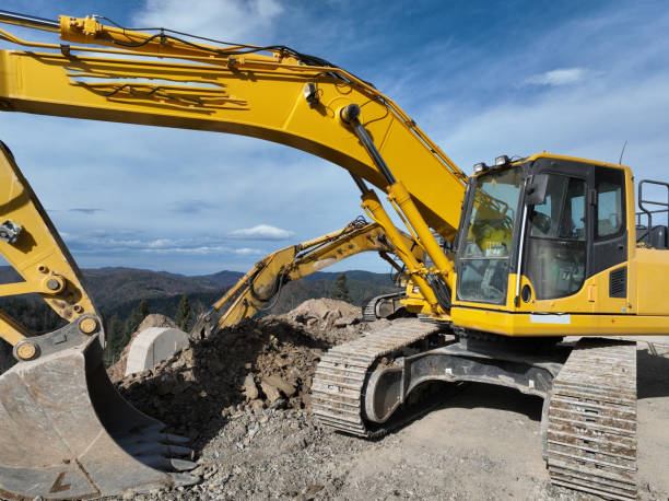 istock Industrial mine excavators are digging the soil in the construction site and loading trucks. Aerial drone top view. 1443519337