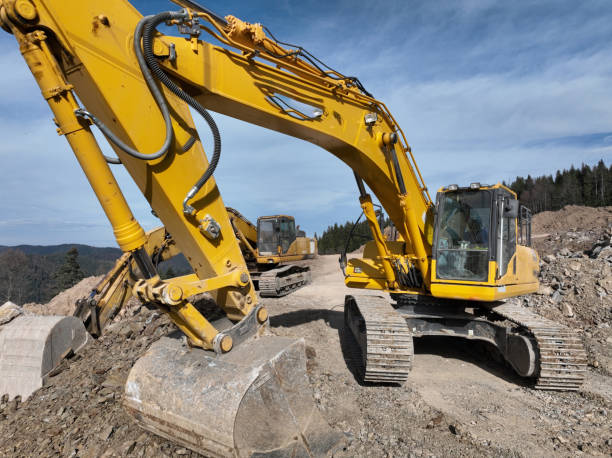 istock Industrial mine excavators are digging the soil in the construction site and loading trucks. Aerial drone top view. 1443519384