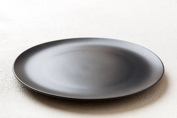 istock Perspective view of empty black plate on cement background. Empty space for your design 1443520680