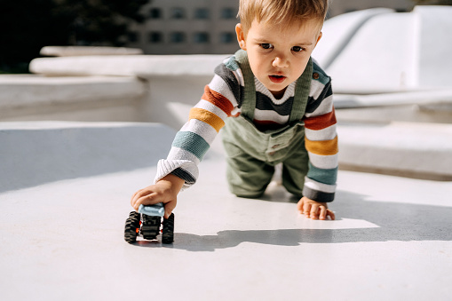 Children kid playing blue color car toy. Child hand playing with car.