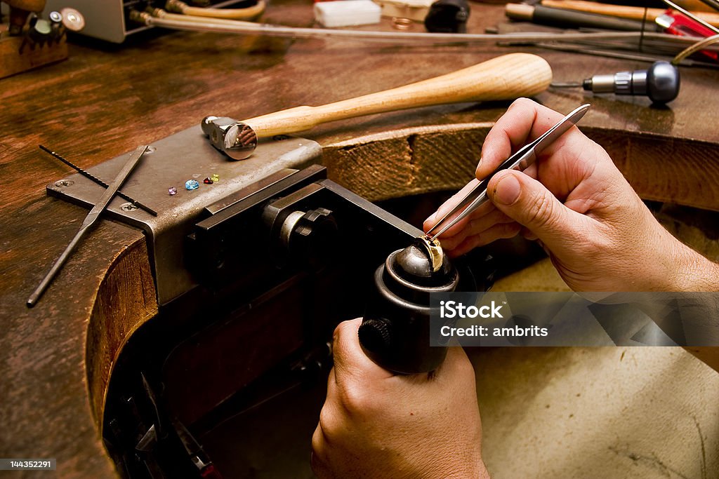 Goldsmith Goldsmith work in process. The goldsmith put a stone into the ring. Jeweller Stock Photo