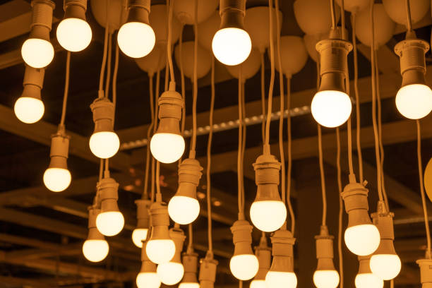 istock Hanging LED Light Bulbs on Blurred Background, Warm Energy Saving Lamp 1443523840