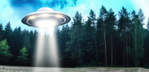 istock Unidentified flying object UFO using teleporting beam in middle of forest 1443523910