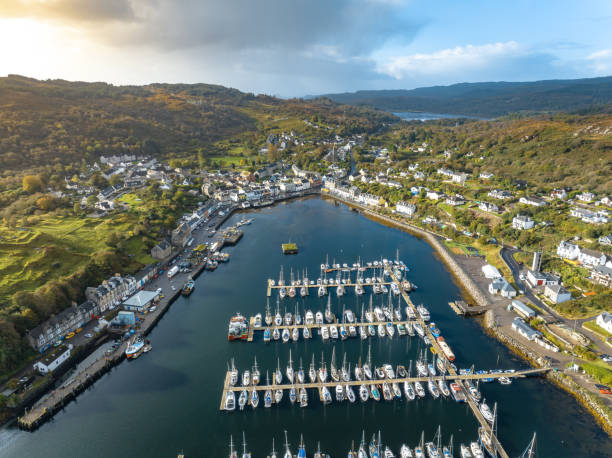 The Fishing Village of Tarbert in Scotland Aerial View Tarbet a small fishing village in Scotland sits on the shores of a loch and is a busy fishing port. The aerial view shows the waterfront, businesses and houses of this beautiful spot in Scotland loch fyne stock pictures, royalty-free photos & images