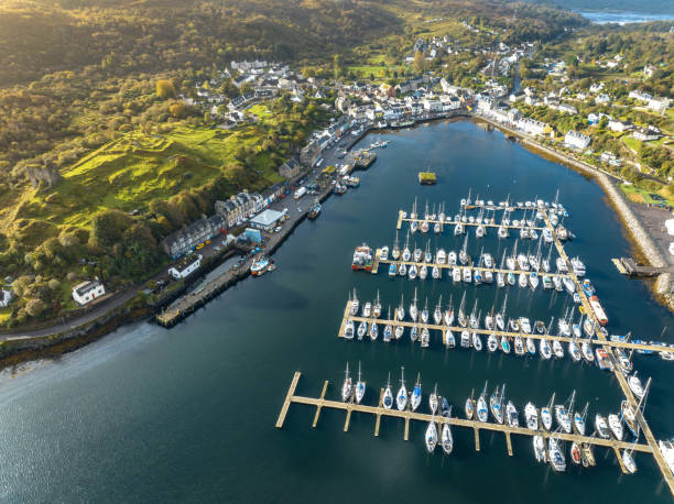 The Fishing Village of Tarbert in Scotland Aerial View Tarbet a small fishing village in Scotland sits on the shores of a loch and is a busy fishing port. The aerial view shows the waterfront, businesses and houses of this beautiful spot in Scotland loch fyne stock pictures, royalty-free photos & images