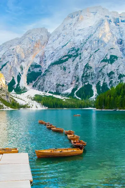 The magnificent Lake Braies with the chain of wooden boats in Dolomites Alps, Italy.