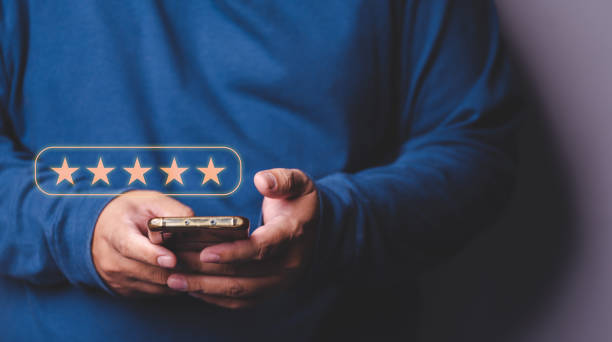istock Customer Service Experience and Business Satisfaction Survey male hand using smartphone with five star symbol icon to increase company concept score 1443526107