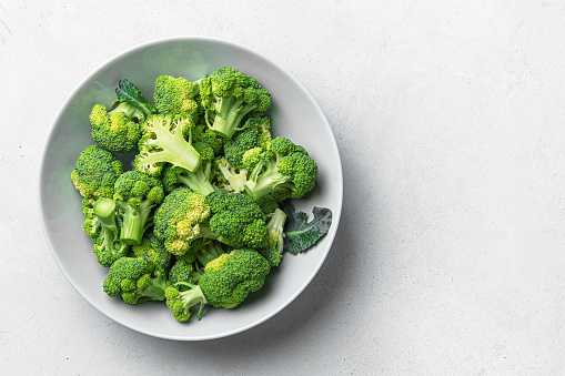 A plate of broccoli on a gray background. Cooking broccoli.