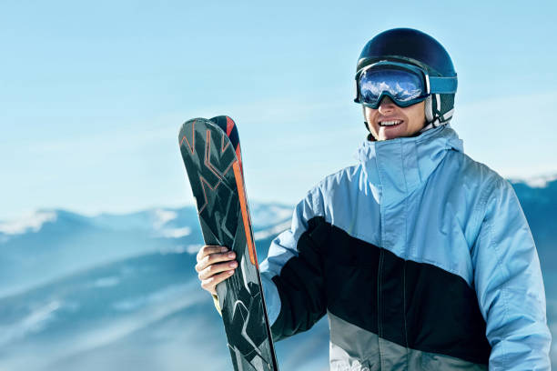 Portrait of a skier in the ski resort on the background of mountains and blue sky, Bukovel.  Ski goggles of a man wearing ski glasses. Winter Sports stock photo
