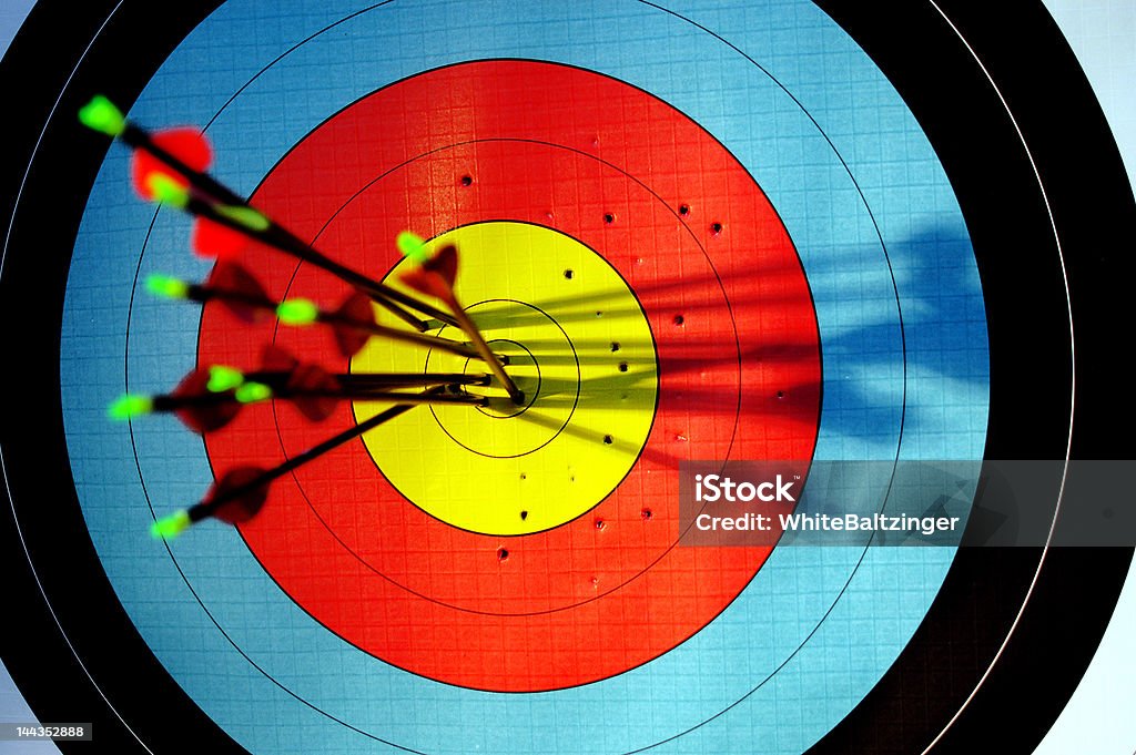 arrows hitting bullseye of archery target 9 arrows in bullseye of archery target Archery Stock Photo