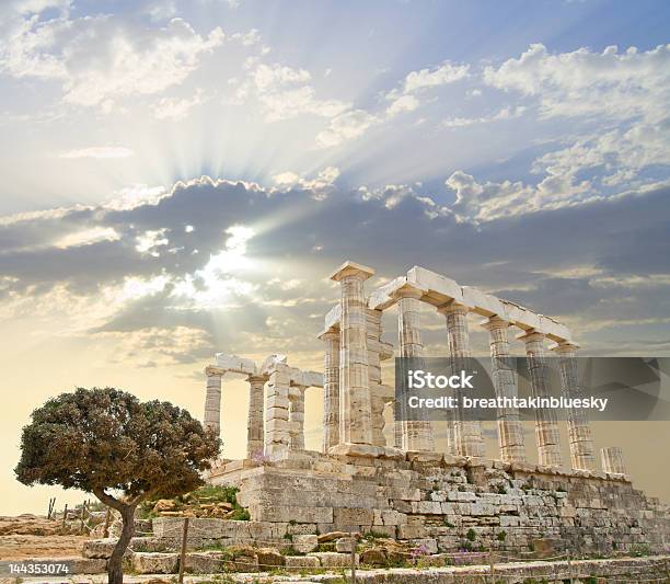 Poseidons Temple In Greece With The Sun Behind The Clouds Stock Photo - Download Image Now