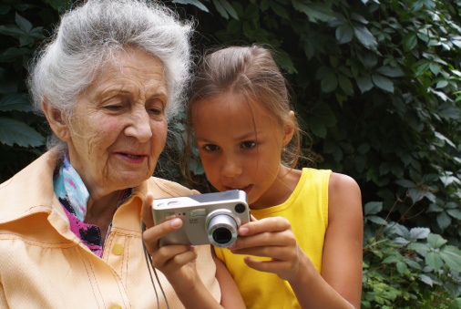 Granddaughter and her grandmother review digital camera pictures 