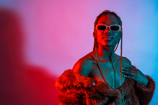 Attractive black woman with braids with red and blue led lights, studio shoot