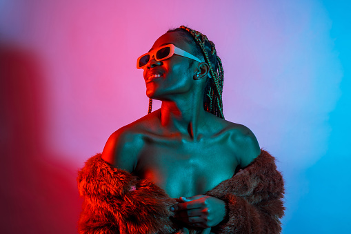Attractive black ethnic woman with braids with red and blue led lights, trap dancer wearing sunglasses