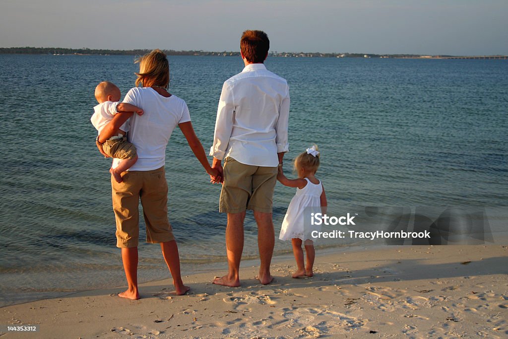 Giovane famiglia sulla spiaggia - Foto stock royalty-free di Abbronzatura