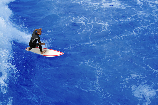 Surfer riding the perfect wave in his surfboard.