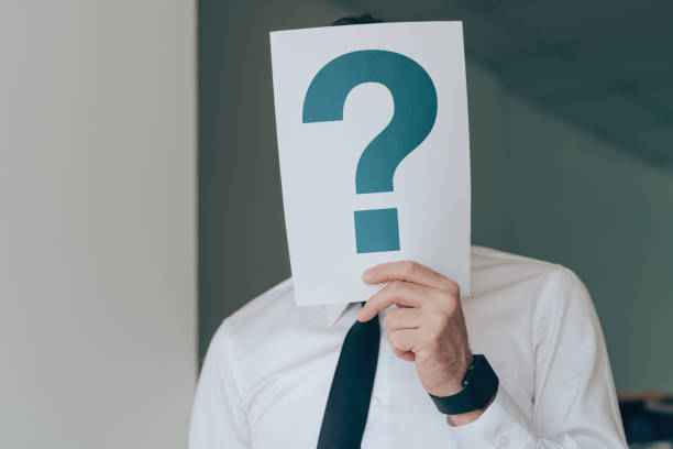 istock Businessman holding paper with printed question mark over his face 1443539251