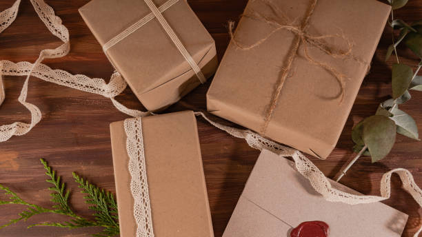 Close up of a small group of kraft gifts over a wooden background stock photo