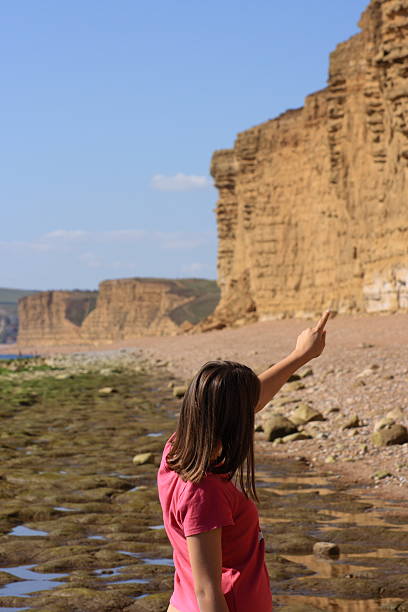 istock Young girl pointing at dramatic coastline 144354353