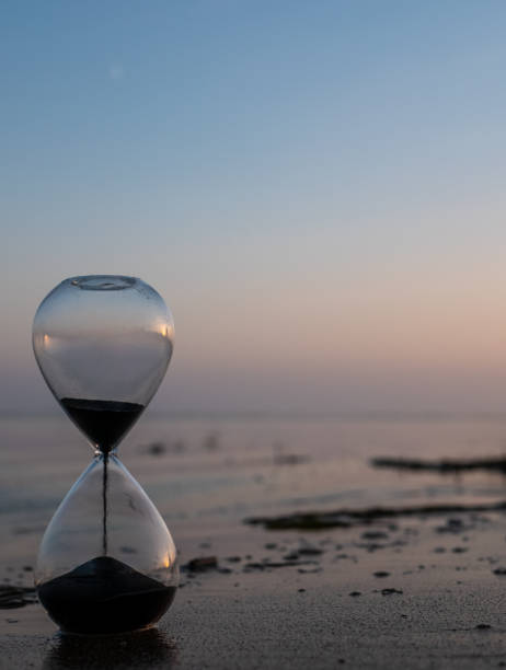 istock Hourglass with black sand at the beach 1443544975