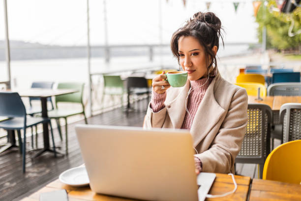istock Young woman using laptop with headphones 1443545929
